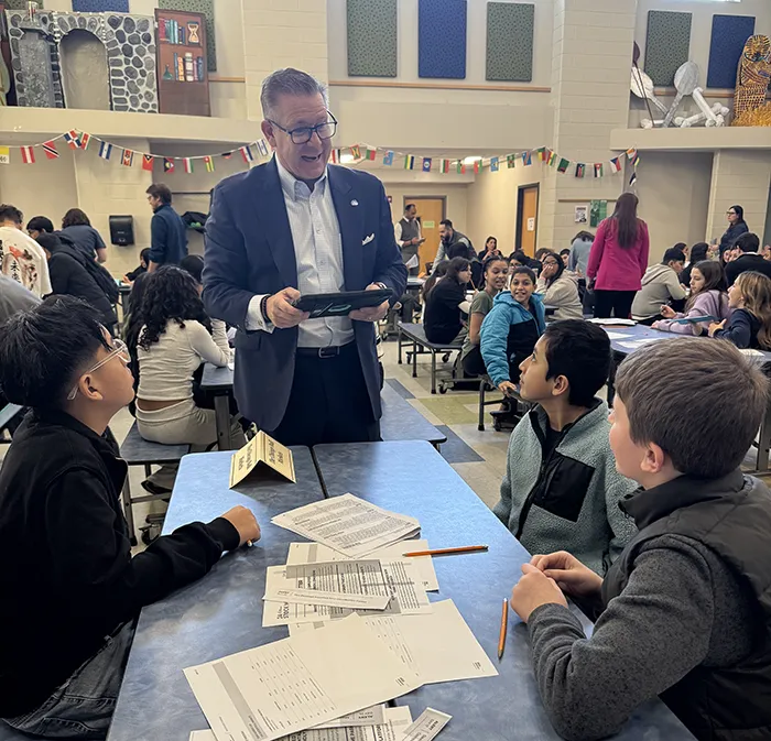 Fairfield County Bank President Daniel Berta assisting a group of students place trades during the simulation.